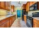 Bright kitchen with wood cabinets, black appliances, and a view to the dining area at 3510 Dellefield St, New Port Richey, FL 34655