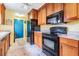 Modern kitchen featuring wood cabinets and black appliances at 3510 Dellefield St, New Port Richey, FL 34655