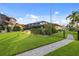 Well-manicured lawn with a walkway to the canal and pool area at 3560 Tripoli Blvd, Punta Gorda, FL 33950