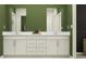 Double vanity bathroom with modern white cabinets and green walls at 3632 Forest Path Dr, Plant City, FL 33565