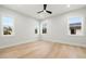 Bedroom featuring hardwood floors, white walls, three windows, and a modern ceiling fan at 3640 15Th N St, St Petersburg, FL 33704