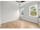 Bedroom featuring hardwood floors, white walls, two windows, and a modern ceiling fan at 3640 15Th N St, St Petersburg, FL 33704