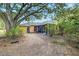 Home's backyard features a screened porch, mature trees, and a large grassy area at 4020 Concord Way, Plant City, FL 33566