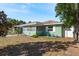 Green house exterior with mature trees and landscaping at 436 Norfolk St, Dunedin, FL 34698