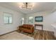 Bright living room features hardwood floors, a brown couch, and a modern chandelier at 436 Norfolk St, Dunedin, FL 34698