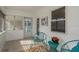 Bright screened porch with teal chairs and potted plants at 436 Norfolk St, Dunedin, FL 34698