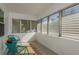 Relaxing screened porch with teal chairs and a small rug at 436 Norfolk St, Dunedin, FL 34698