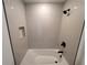 Modern bathroom with a bathtub and shower, featuring sleek fixtures and neutral-toned tile at 5402 Ojus St, North Port, FL 34286