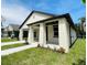 Charming single-story home featuring a covered porch, white brick, dark trim, and well-maintained landscaping at 5701 N 20Th St, Tampa, FL 33610