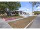 House exterior showcasing a white single story home with pink accents and a large tree at 600 30Th N St, St Petersburg, FL 33713