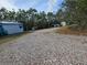 Gravel driveway leading to a mobile home and outbuildings at 6274 Boatwrite Rd, Spring Hill, FL 34609