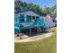 Mobile home with large deck, American flag, and spacious yard at 6274 Boatwrite Rd, Spring Hill, FL 34609