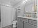 Modern bathroom with gray vanity, granite countertop and shower/tub combo at 821 Forest Glen Ct, Palm Harbor, FL 34683