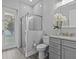 Clean bathroom with gray vanity, shower, and white tile at 821 Forest Glen Ct, Palm Harbor, FL 34683