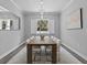 Elegant dining room with wood table, white chairs, and large window at 821 Forest Glen Ct, Palm Harbor, FL 34683