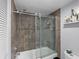 Bathroom with gray tile, glass shower, and tub at 8703 Bardmoor Blvd # 106, Seminole, FL 33777