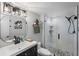 Bathroom with round mirror, dark vanity, and walk-in shower at 8703 Bardmoor Blvd # 106, Seminole, FL 33777