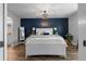 Bright bedroom with white bed frame, wood floors, and a navy accent wall at 8703 Bardmoor Blvd # 106, Seminole, FL 33777