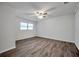 Bright bedroom with wood-look floors, ceiling fan and two windows at 9100 52Nd N Way, Pinellas Park, FL 33782