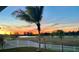 Sunset view from backyard with white fence and palm trees at 935 Signet Dr, Apollo Beach, FL 33572