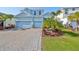 Two-story light blue house with a three-car garage and landscaped front yard at 935 Signet Dr, Apollo Beach, FL 33572