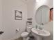 Stylish powder room with pedestal sink and round mirror at 935 Signet Dr, Apollo Beach, FL 33572