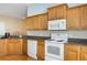 Bright kitchen, featuring wood cabinets and granite countertops at 9551 Jaybird Ln, Land O Lakes, FL 34638