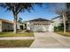 Single-story house with attached garage, manicured lawn, and walkway at 9607 Maxson Dr, Land O Lakes, FL 34638