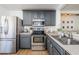 Modern kitchen with stainless steel appliances and gray cabinets at 9607 Maxson Dr, Land O Lakes, FL 34638