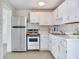 Small kitchen with white cabinets, stainless steel appliances, and terrazzo floor at 10463 118Th Ave, Largo, FL 33773