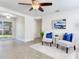 Bright living room with two gray chairs, blue pillows, and a large window at 10463 118Th Ave, Largo, FL 33773