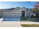 Tan three-car garage house with lush landscaping at 10721 Rockledge View Dr, Riverview, FL 33579