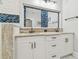 Modern bathroom with white cabinets, double vanity, and blue tile accents at 111 W Ida St, Tampa, FL 33603