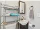 Small bathroom with pedestal sink and metal shelving unit at 111 W Ida St, Tampa, FL 33603