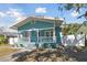 Charming light blue house with white porch and fenced yard under a blue sky at 111 W Ida St, Tampa, FL 33603