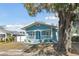 Light blue house with white trim and porch, featuring a large tree in the yard at 111 W Ida St, Tampa, FL 33603