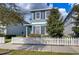 Charming two-story home features a light blue exterior, white picket fence, and neatly manicured front yard at 11308 Great Neck Rd, Riverview, FL 33578