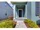 Inviting front entrance with a black door, arched porch, stone pathway, and colorful landscaping at 11308 Great Neck Rd, Riverview, FL 33578