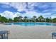 Large community pool with lounge chairs, palm trees, and a covered gazebo for relaxing poolside at 11308 Great Neck Rd, Riverview, FL 33578