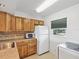 Updated kitchen with wood cabinets, microwave, and full-size refrigerator at 11485 Oakhurst Dr # 1100-312, Largo, FL 33774