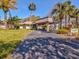 Community recreation center exterior with palm trees and a paved driveway at 11485 Oakhurst Dr # 1100-312, Largo, FL 33774