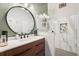 Stylish bathroom, featuring a round mirror, modern vanity, and a large walk-in shower at 13345 14Th St, Dade City, FL 33525