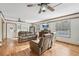 Living room with hardwood floors, two sofas, and ceiling fans at 13345 14Th St, Dade City, FL 33525