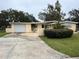 Ranch style home with carport, basketball hoop, and mature landscaping at 1373 Fairfax Rd, Clearwater, FL 33764