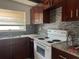 Galley kitchen with dark wood cabinets and granite countertops at 1373 Fairfax Rd, Clearwater, FL 33764