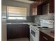 Galley kitchen with dark wood cabinets and granite countertops at 1373 Fairfax Rd, Clearwater, FL 33764