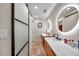 Bright bathroom featuring a double vanity and a sliding barn door at 1753 Lucas Dr, Clearwater, FL 33759