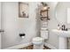 Modern bathroom with pedestal sink, toilet and stylish floating shelves at 17806 Althea Blue Pl, Lutz, FL 33558