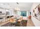 Open concept dining area with glass table and modern light fixture adjacent to kitchen at 17806 Althea Blue Pl, Lutz, FL 33558