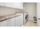 Laundry room with white cabinets, granite countertop and a washer and dryer at 17806 Althea Blue Pl, Lutz, FL 33558